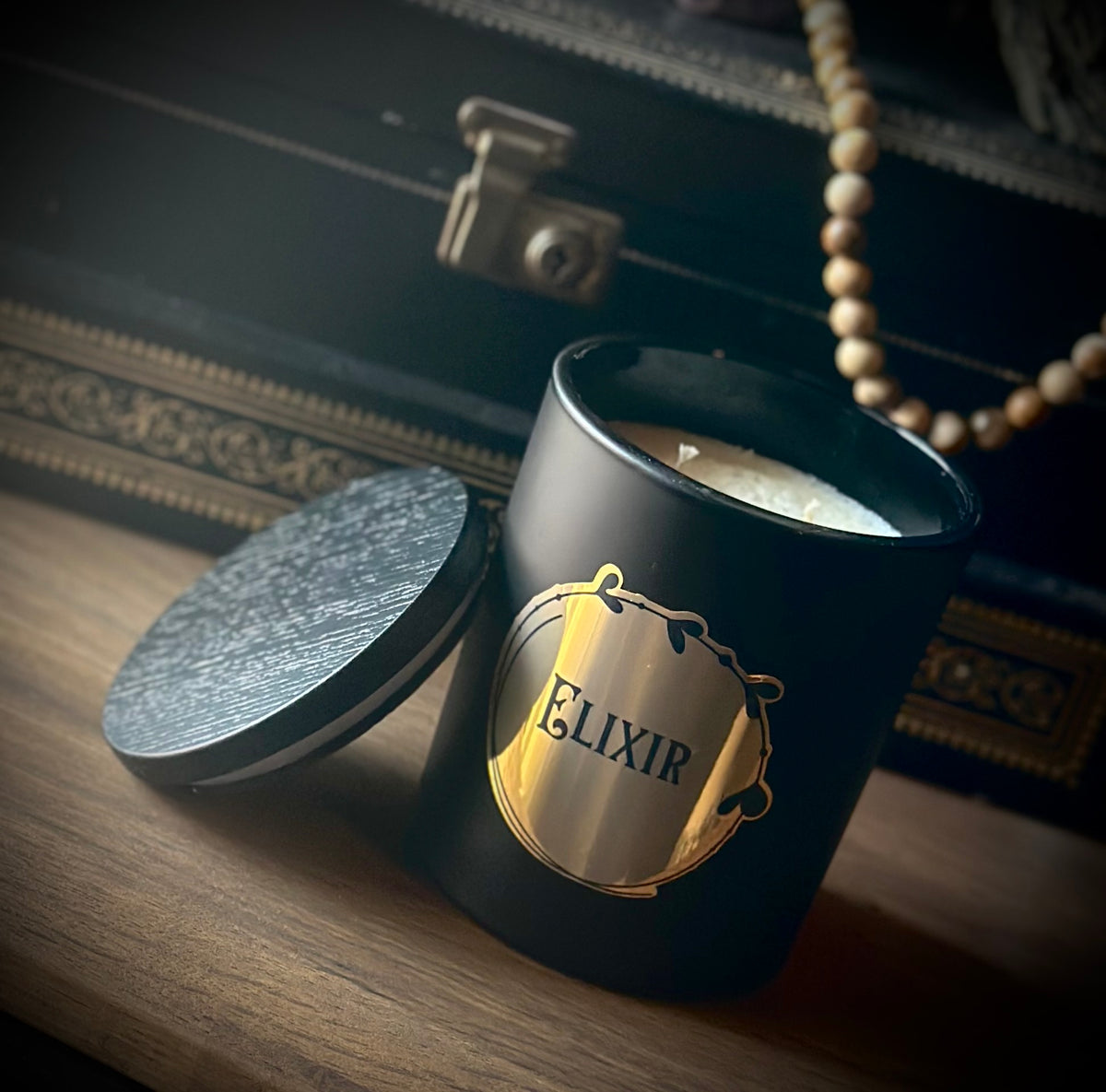 Elixir gothic jar candle in matt black glass with metallic gold label, scented with thyme, lavender, patchouli and cedarwood without lid