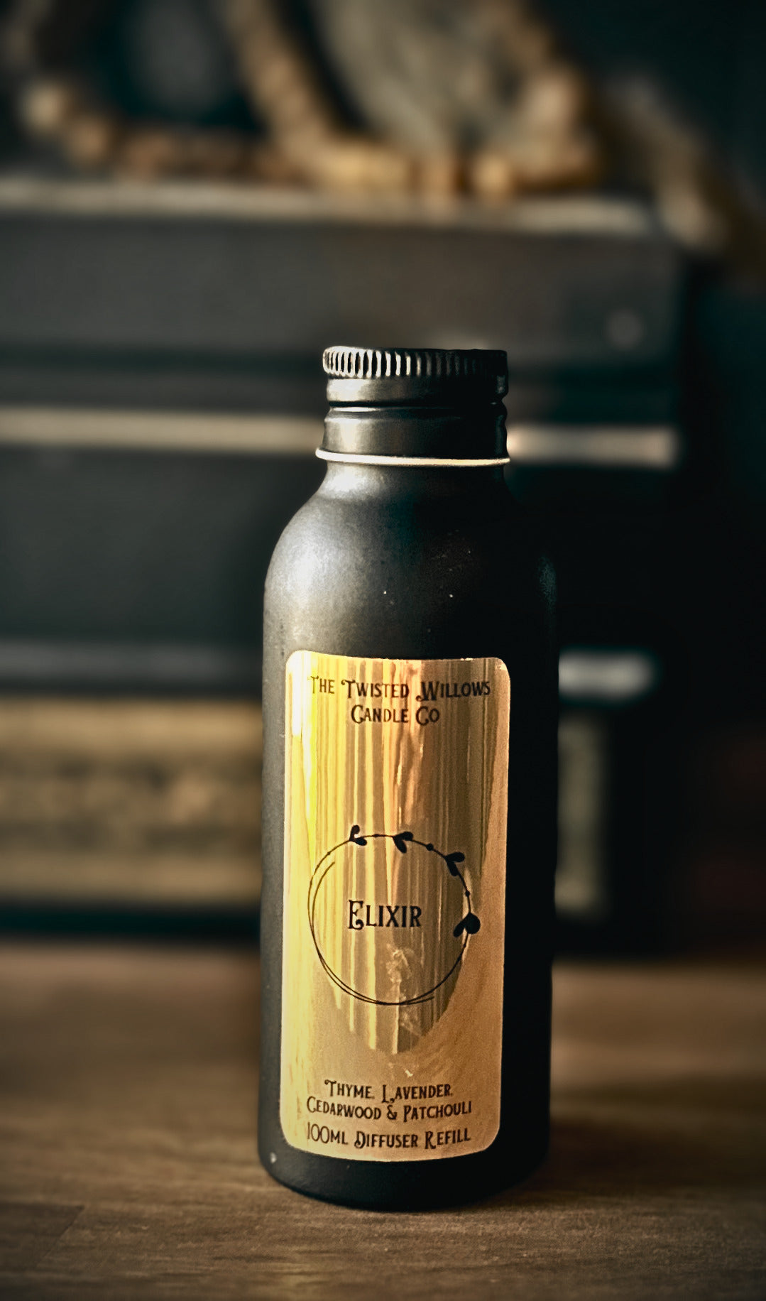 Matt black bottle with metallic gold label. Elixir Reed Diffuser Refill with 7 black reeds.