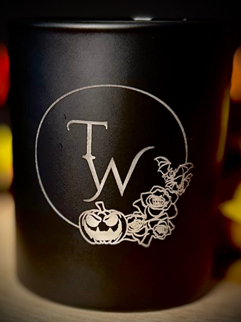 Detailed close-up of the spooky bat and black rose etching on the candle jar.