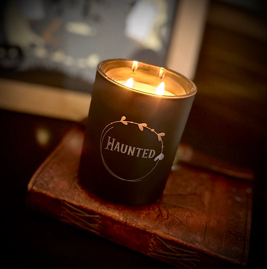 Haunted candle nestled on a gothic journal - a gothic centrepiece for dark aesthetics.