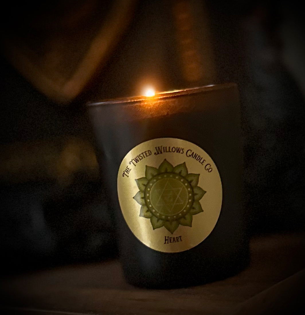Lighting a heart chakra candle for emotional balance and renewal in a sacred self-care space.