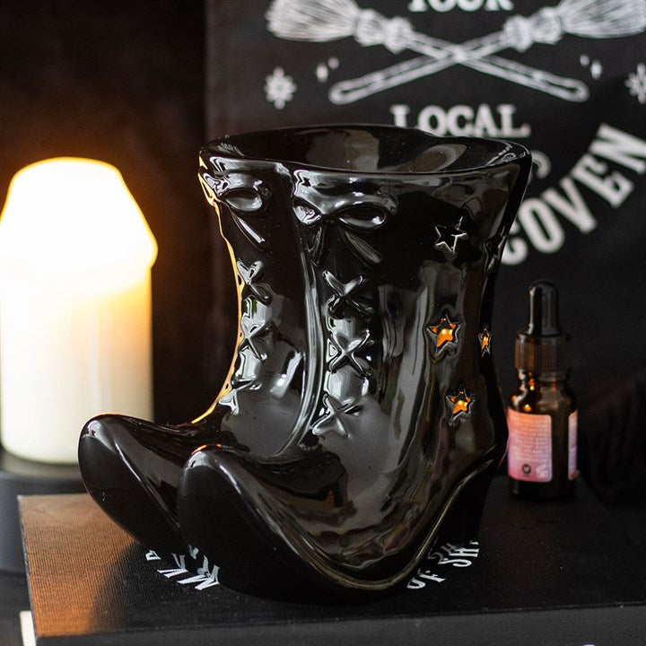 Gothic black ceramic witch's boot oil burner with star cut-outs showing flame glow.
